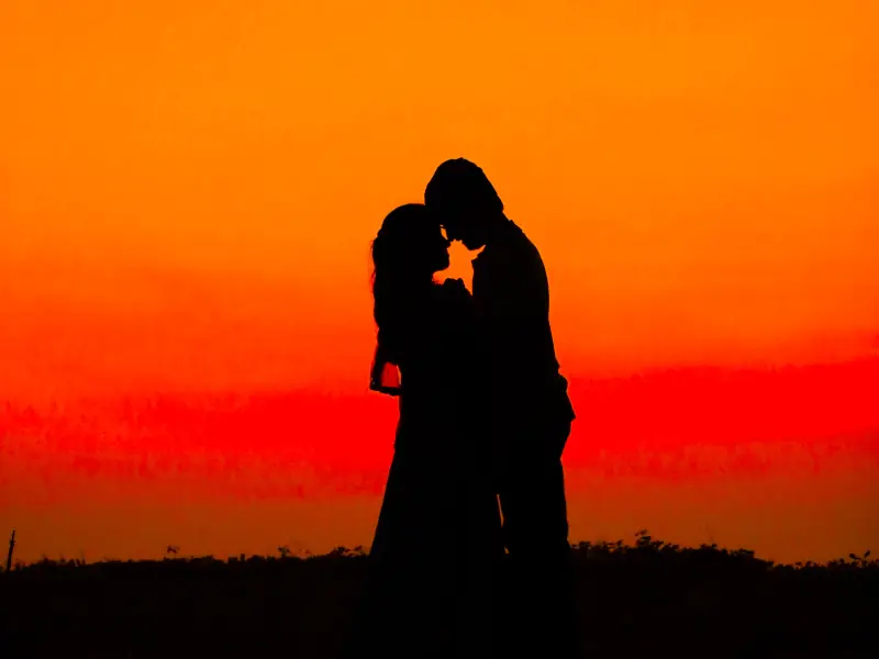 Couple kissing by the dusk.
